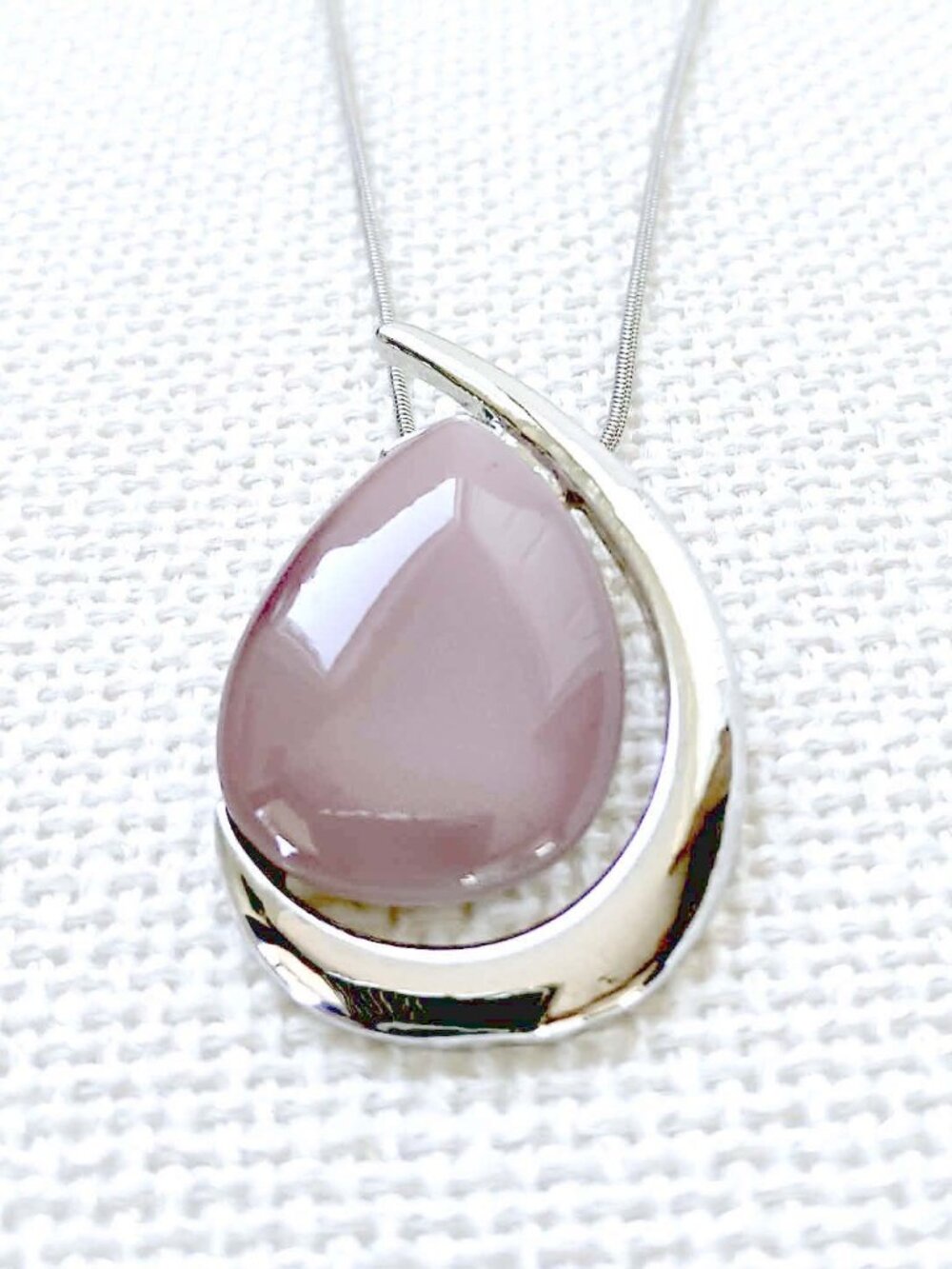 Elegant teardrop necklace smooth soft-pink stone set in a silver-tone pendant